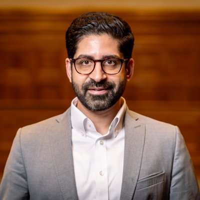 Hessens Wirtschaftsminister Kaweh Mansoori vor braunem Hintergrund